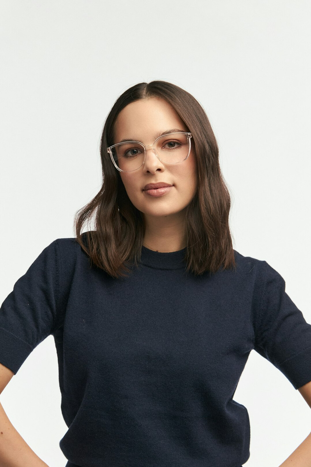 Studio portrait of a smiling woman with glasses